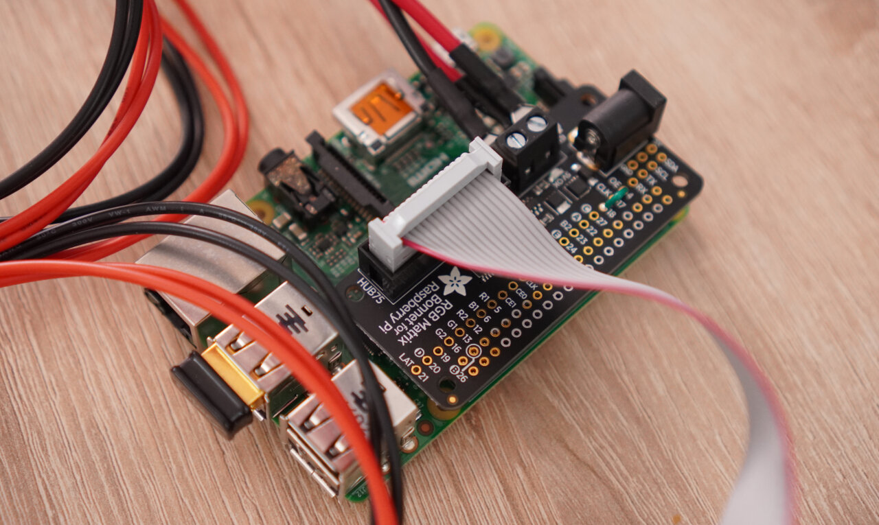 Photo of the Raspberry Pi 2 with the Adafruit RGB Matrix Bonnet and a Wifi dongle.