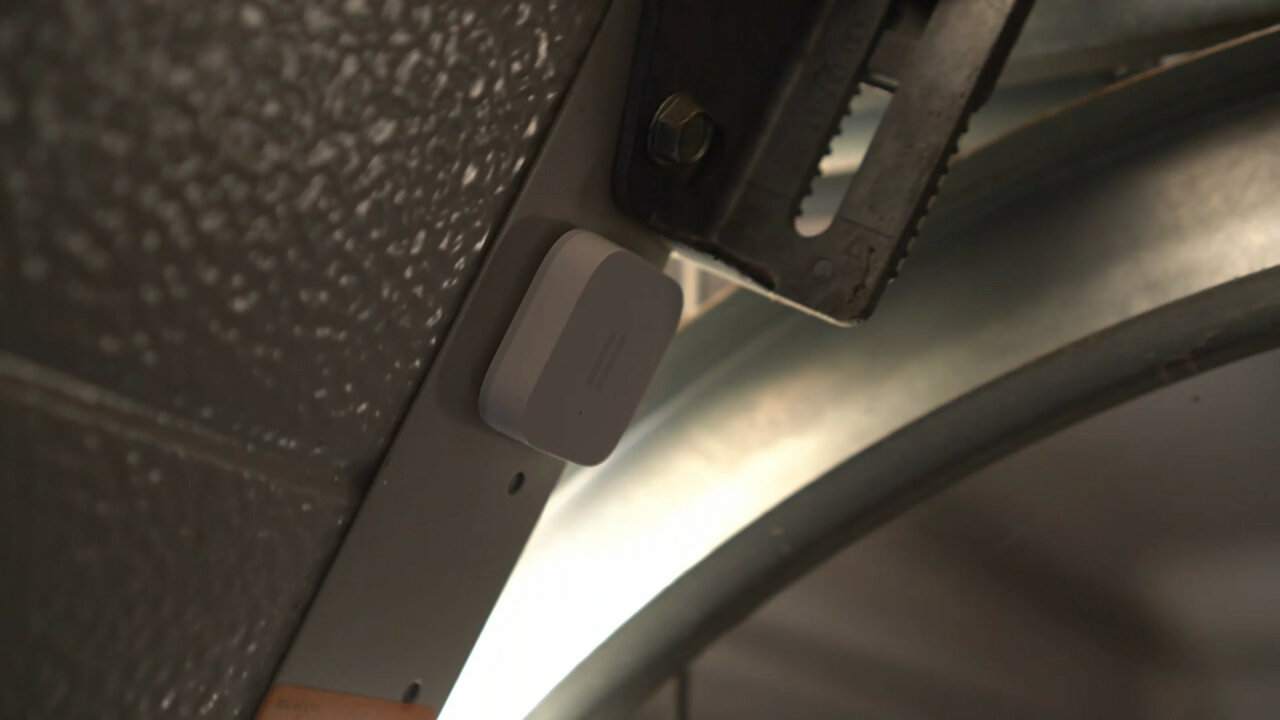 Photo of the Xiaomi Aqara Vibration sensor attached to the garage door.