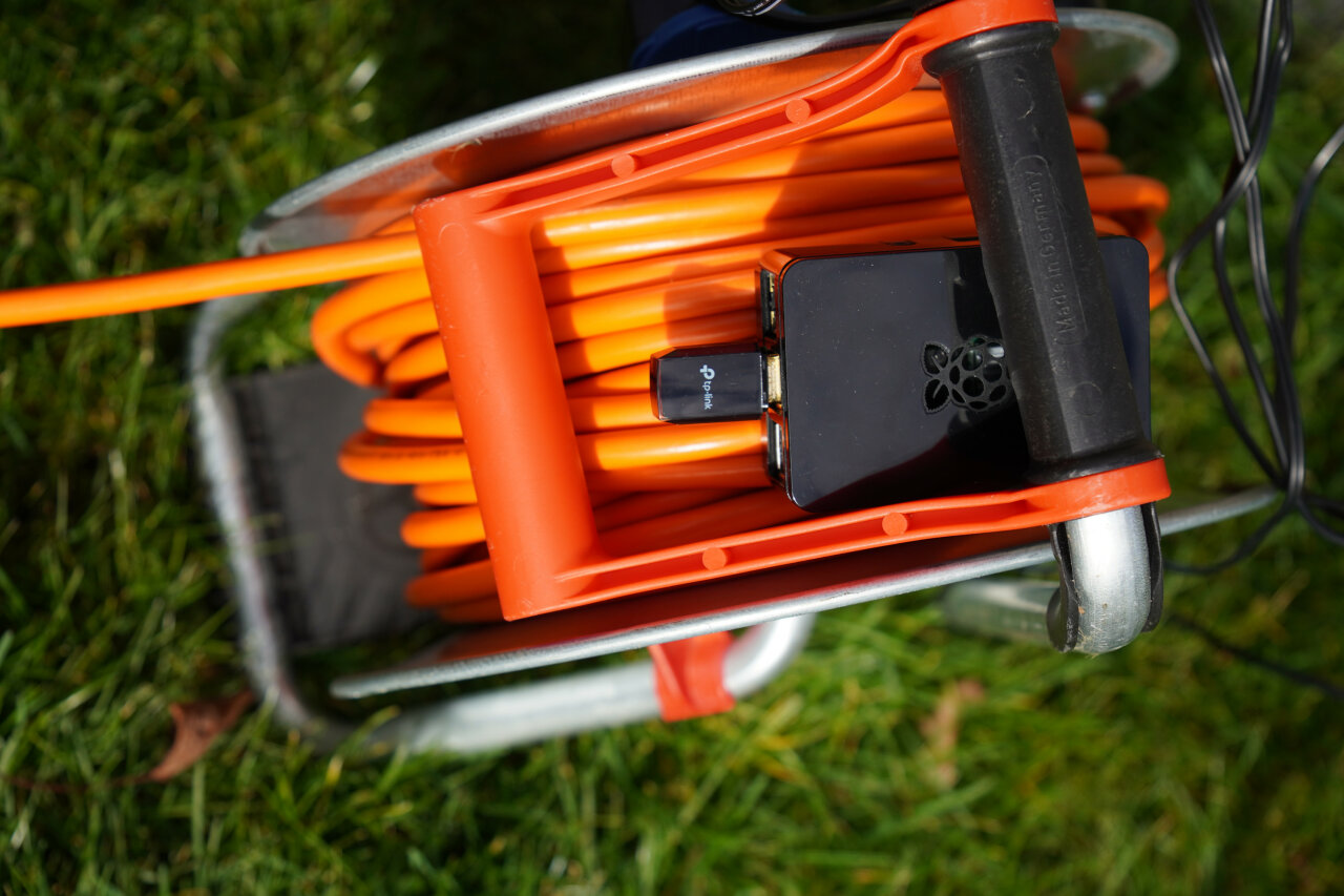 A Raspberry Pi in a case is just placed carelessly on a cable drum.