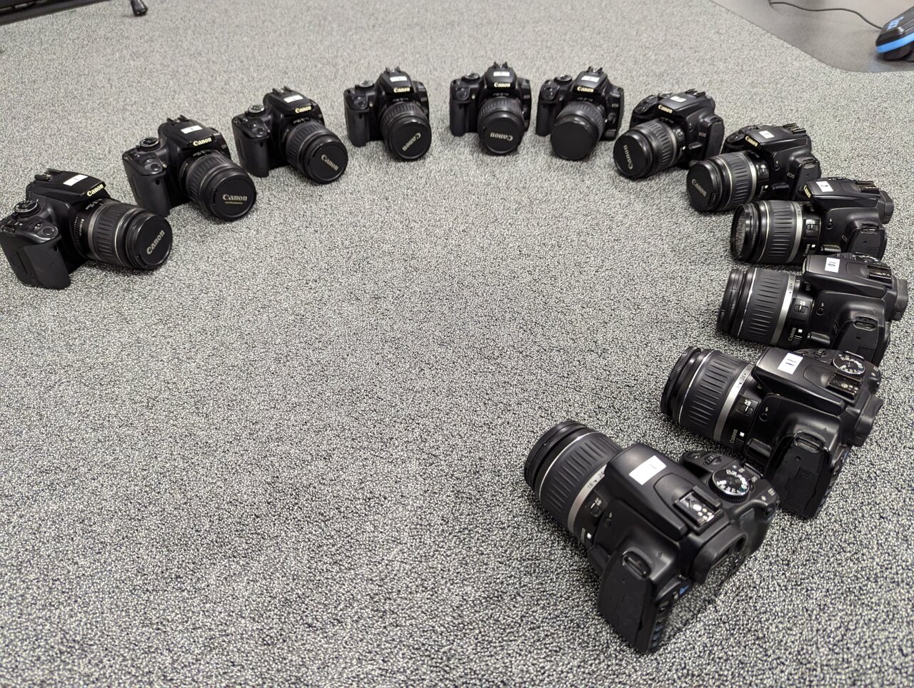 Photo of twelve Canon EOS 400d arranged in a circle on the floor.