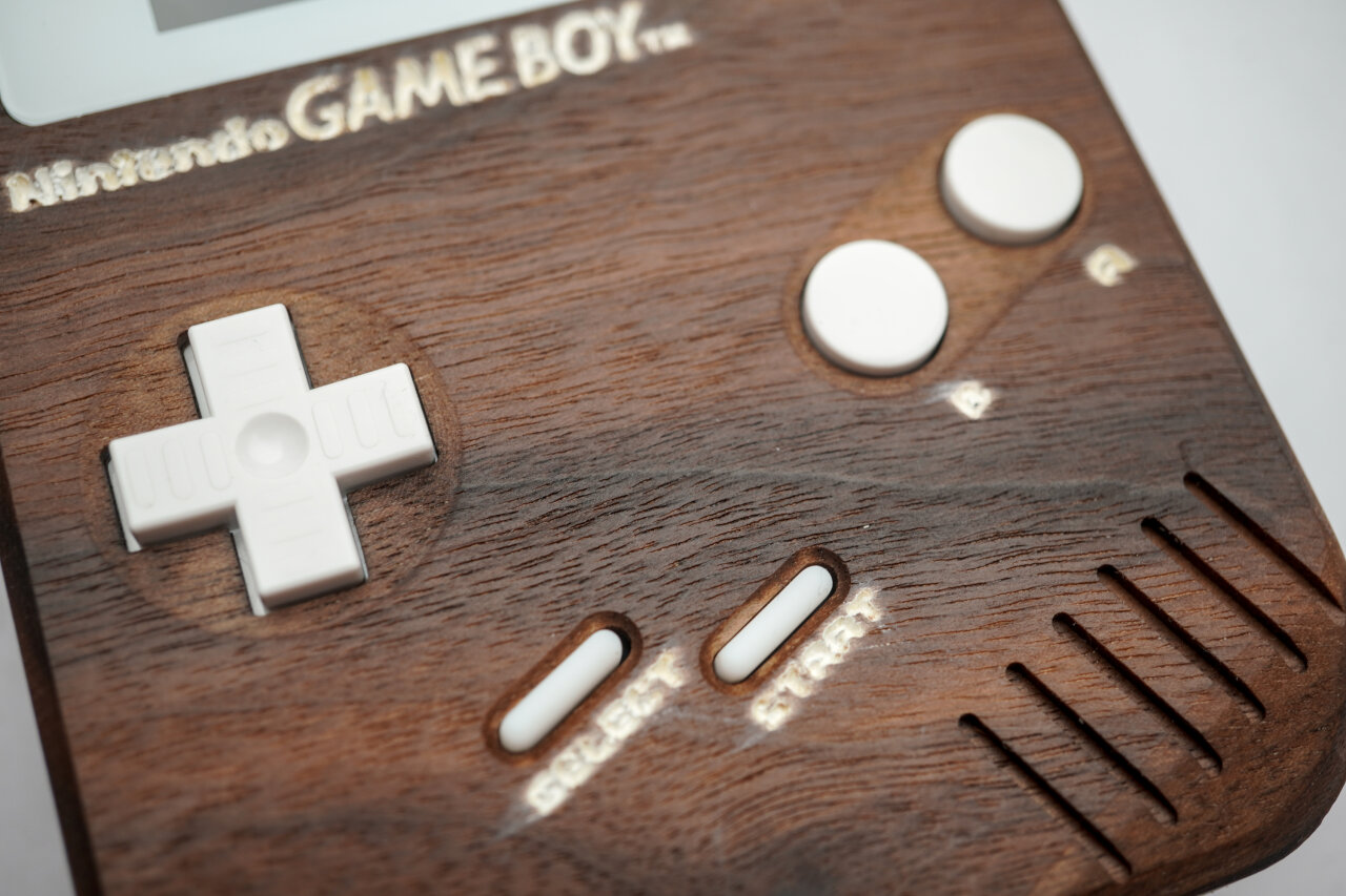 Detail photo of the button area of the wooden Game Boy. The Nintendo logo as well as the labels next to the buttons suffer a bit from a smeared out look.